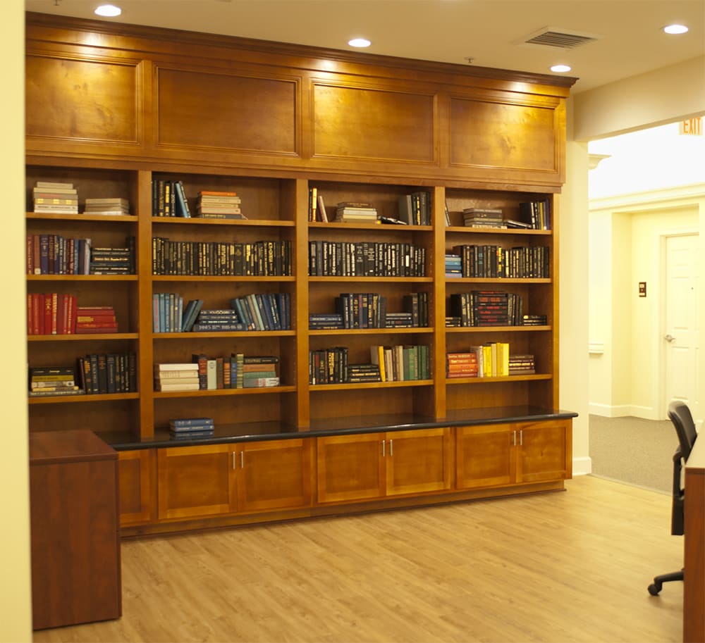 A cozy library corner with wooden bookshelves filled with various books.