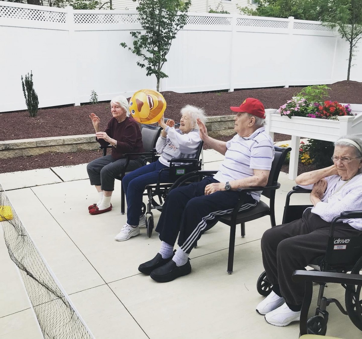 A group of elderly people sitting outdoors, enjoying a peaceful moment together.