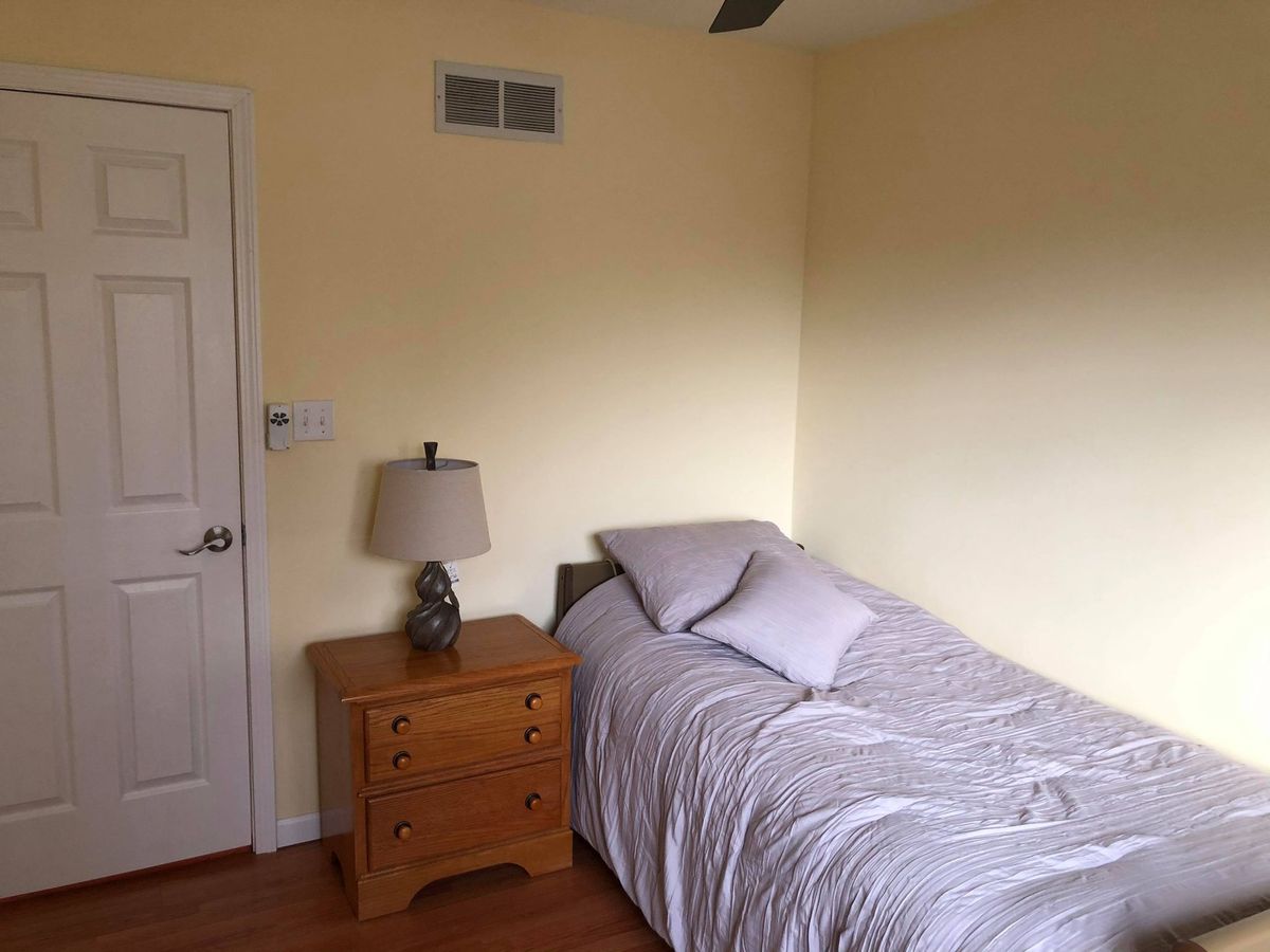 A minimalist bedroom with a single bed and nightstand.