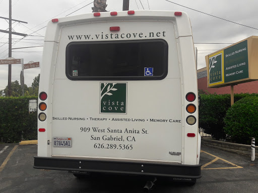 A bus from Vista Cove parked in San Anselmo, California, displaying their website and contact information.