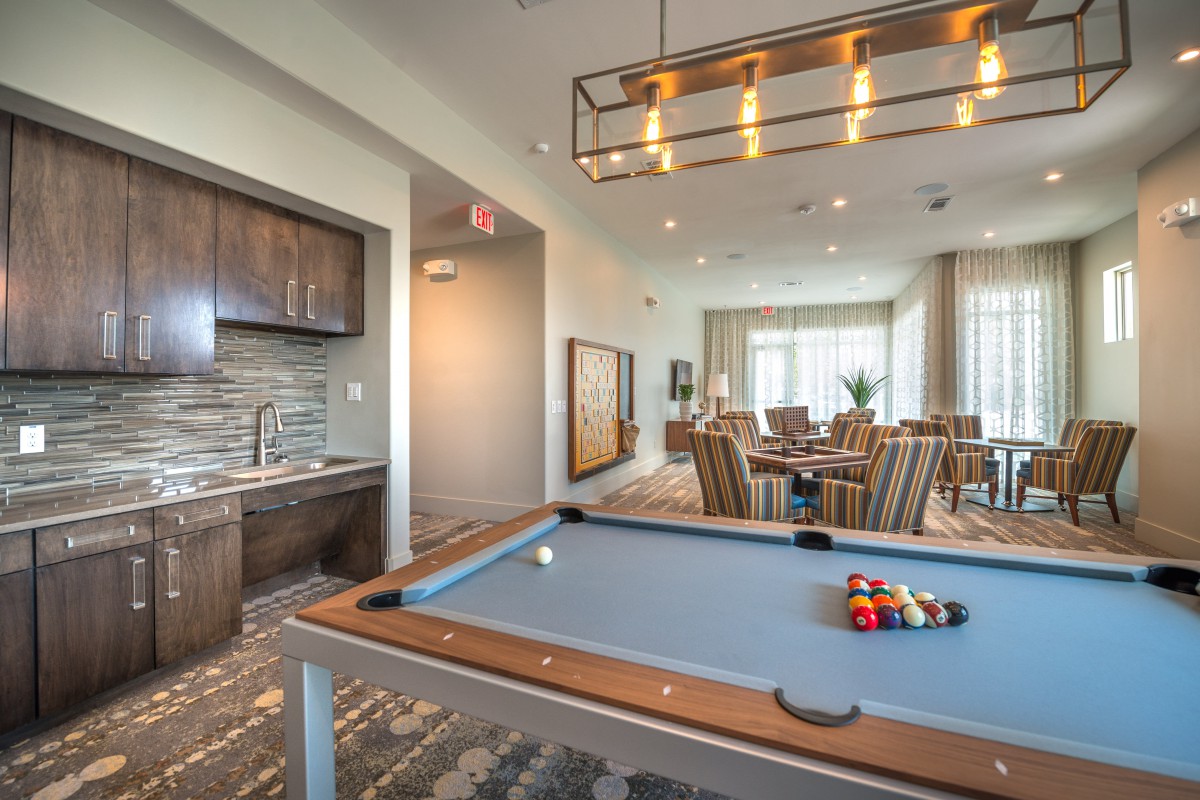 A modern game room featuring a pool table and stylish lighting.