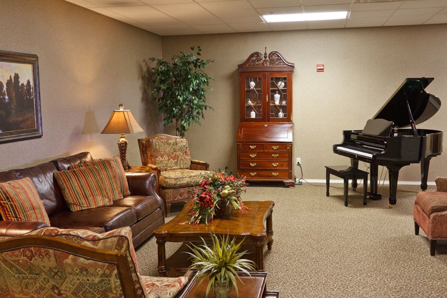 A cozy living room with a piano and classic furniture arrangement.