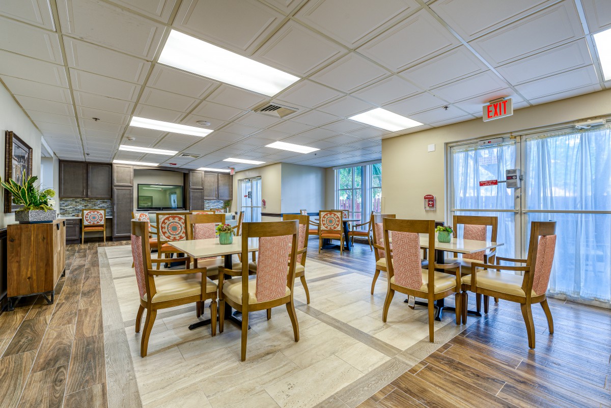 A well-lit dining area with multiple tables and chairs arranged neatly.