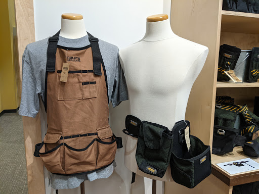 Display of a work apron and a tool belt on mannequins, showcasing practical crafting accessories.