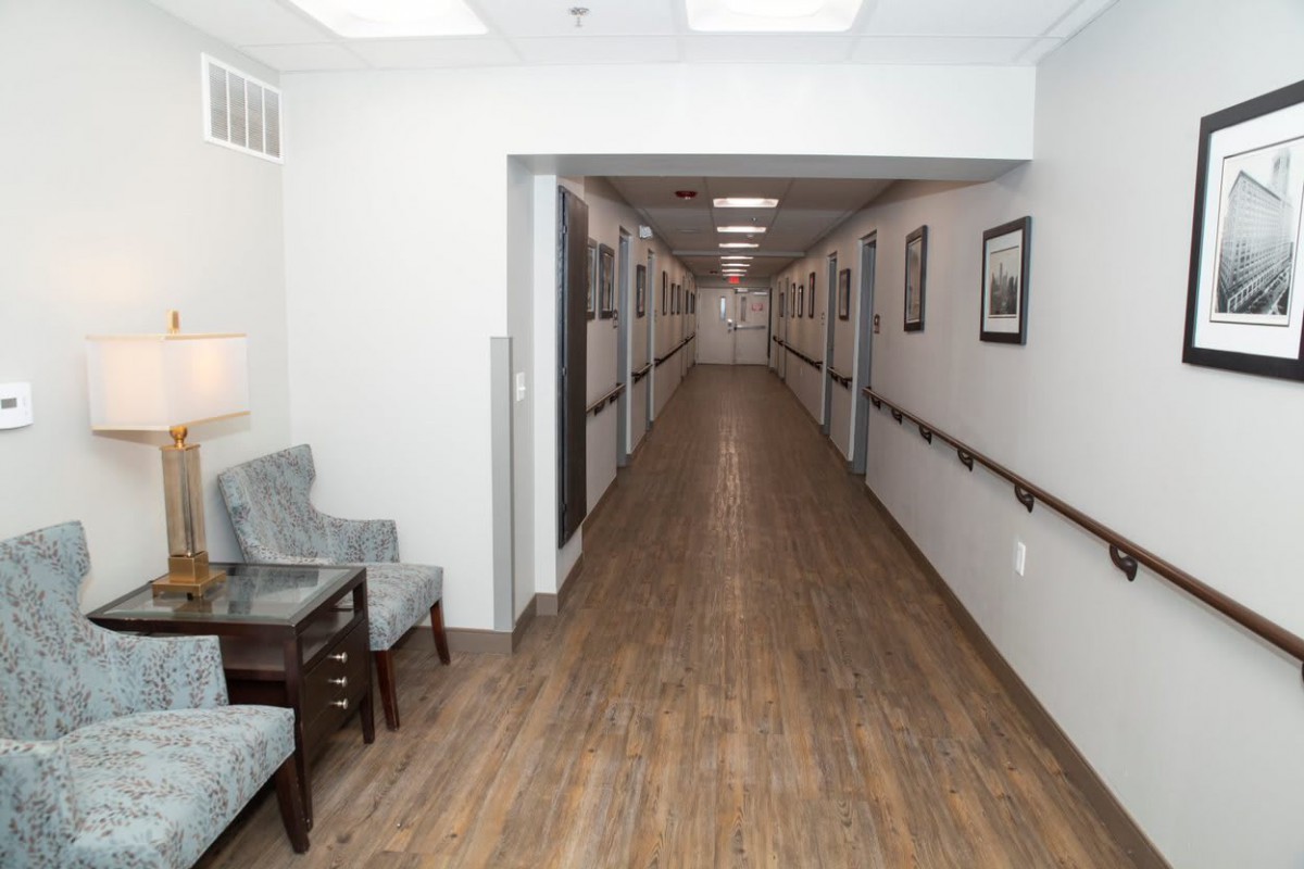 A view of a long, well-lit hallway with seating arrangements and decorative elements along the walls.