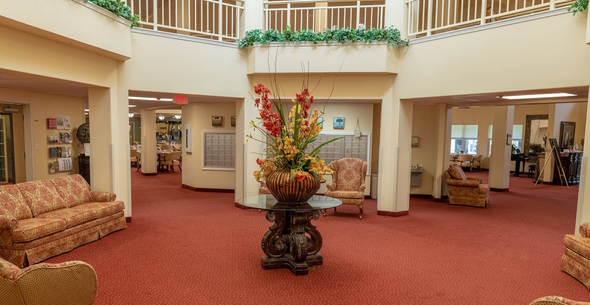 A well-decorated lobby with a central floral arrangement and seating area.