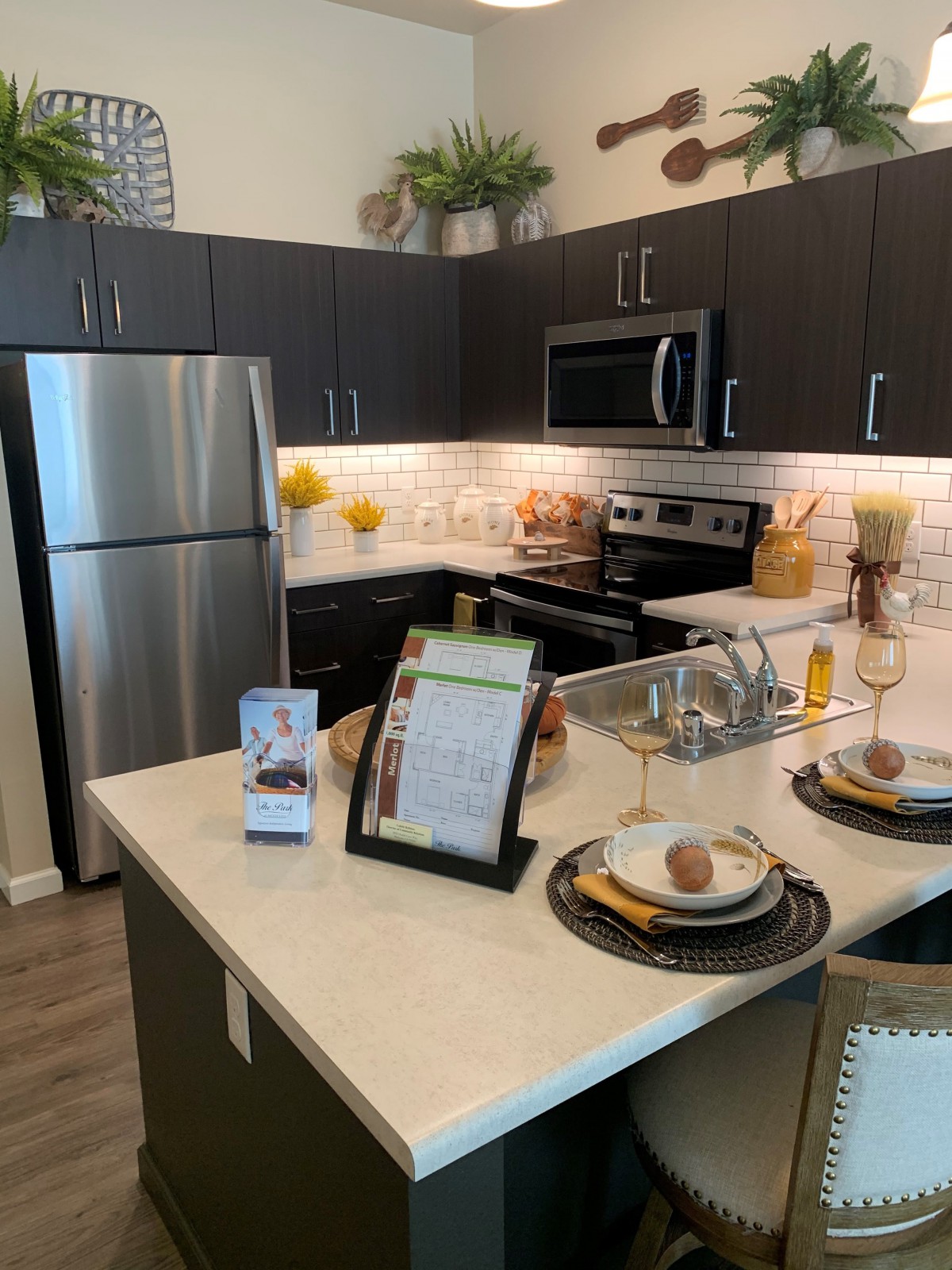 A modern kitchen featuring stainless steel appliances and an island with dining setup.