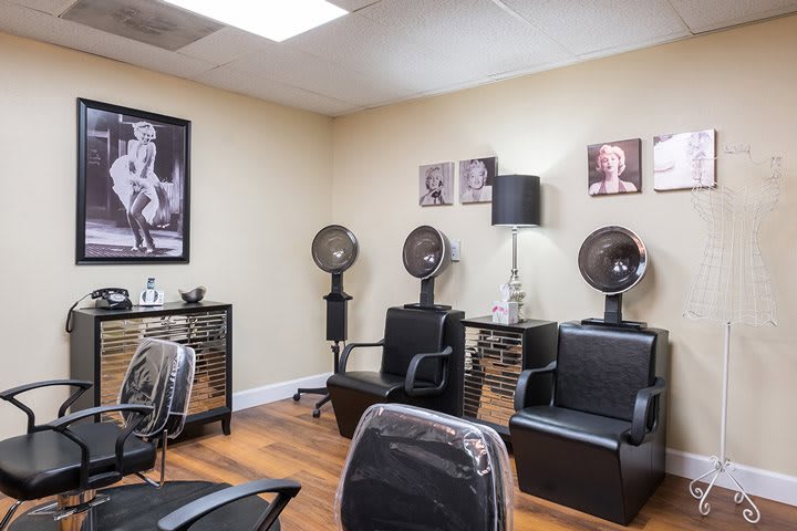 Cozy salon interior with hair dryers and comfortable chairs.