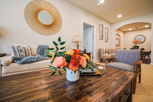 A cozy living room featuring a beautiful floral arrangement on a wooden table, complemented by modern decor elements.