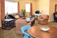 A cozy living room with various seating options and a workspace.