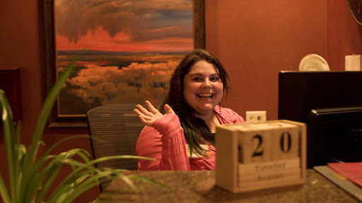 A friendly receptionist greets visitors with a warm smile.