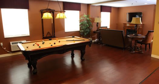 A cozy game room with a pool table and elegant lighting.