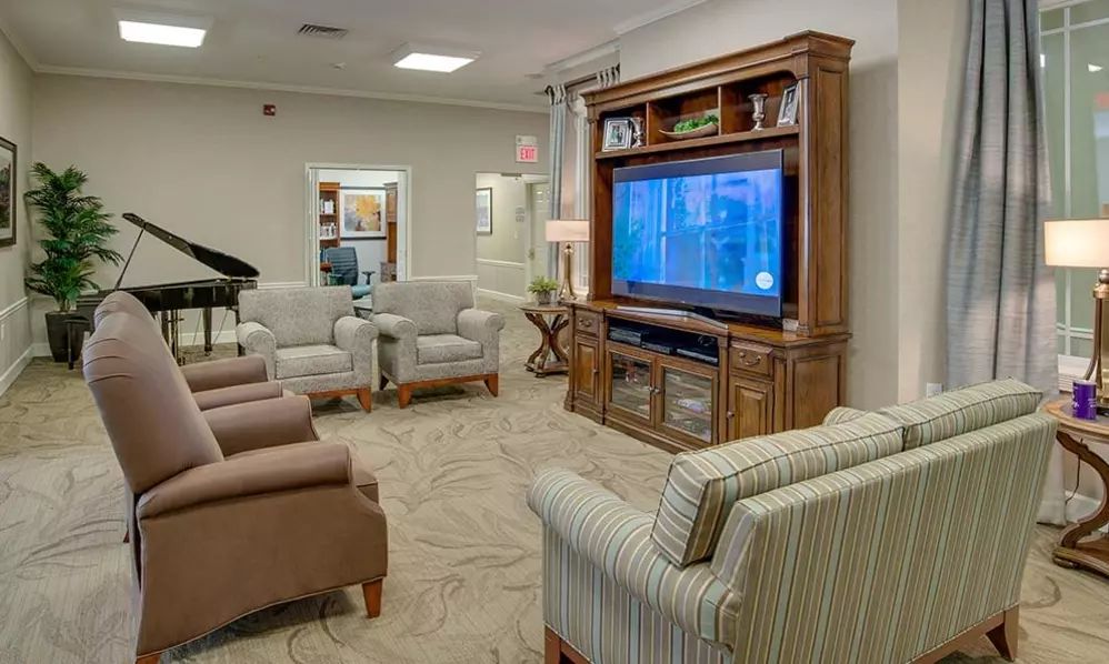 A cozy living room with comfortable seating and a large television entertainment center.