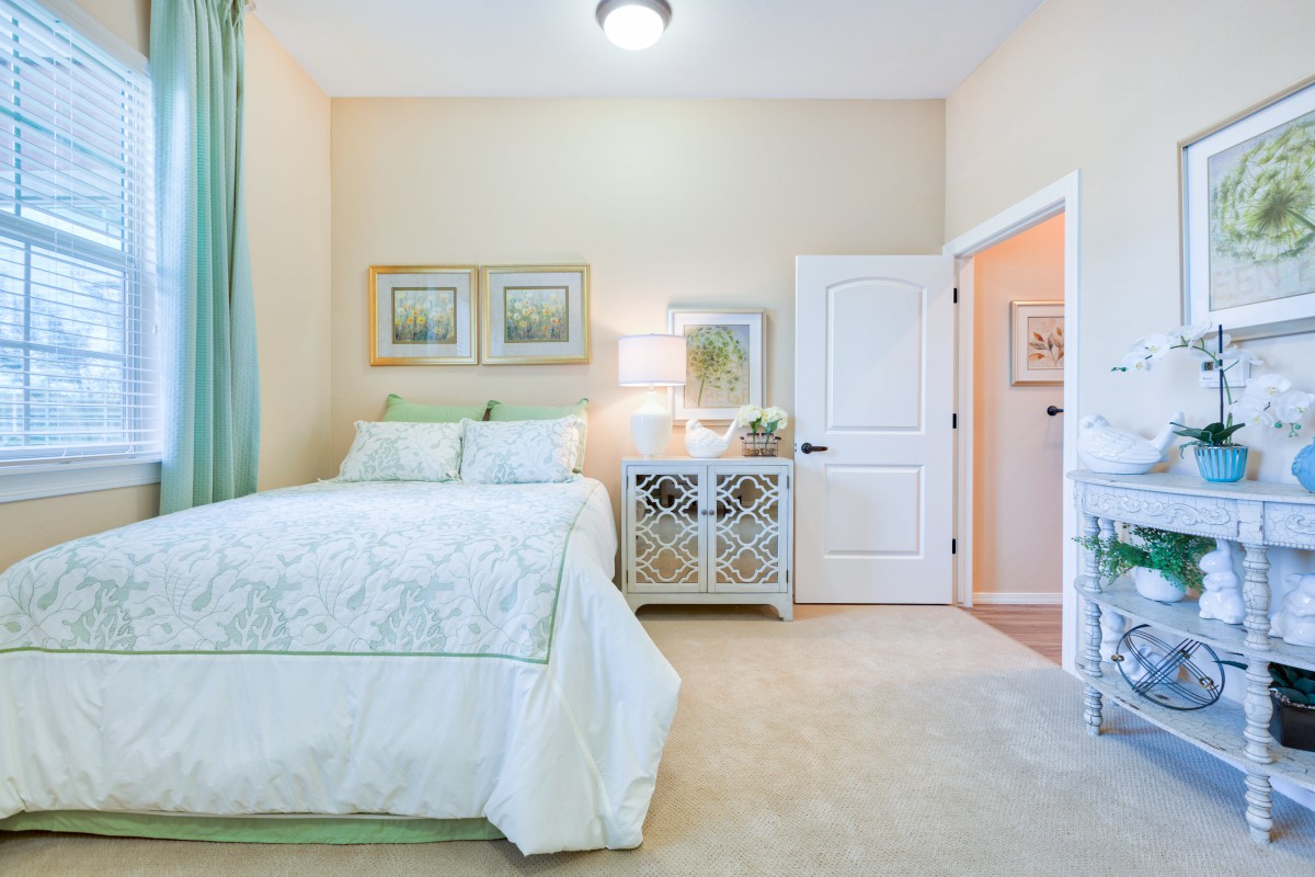 A cozy and elegantly decorated bedroom with a double bed, nightstand, and soft lighting.