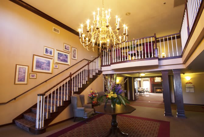 Elegant hotel lobby with a grand staircase and chandelier.