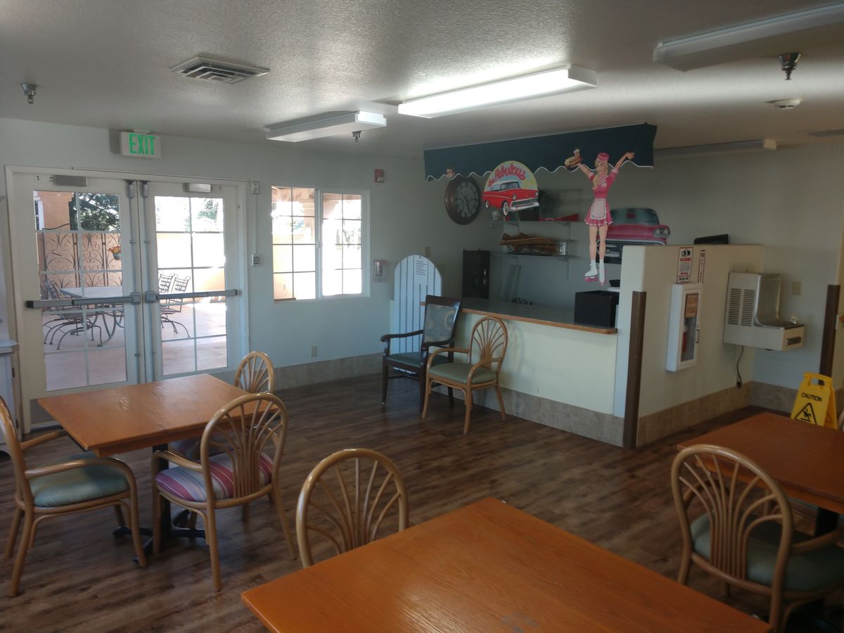 An interior view of a small restaurant dining area with tables and chairs.
