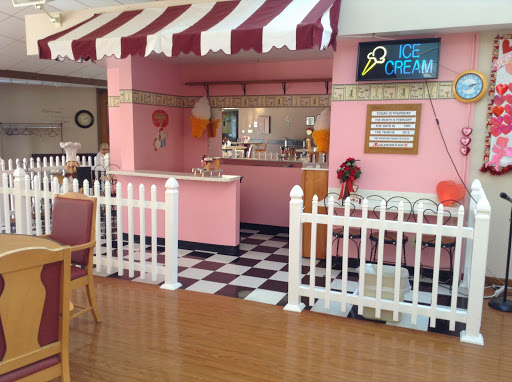 A charming ice cream shop with a pink theme, featuring a candy-striped awning and a classic checkered floor.