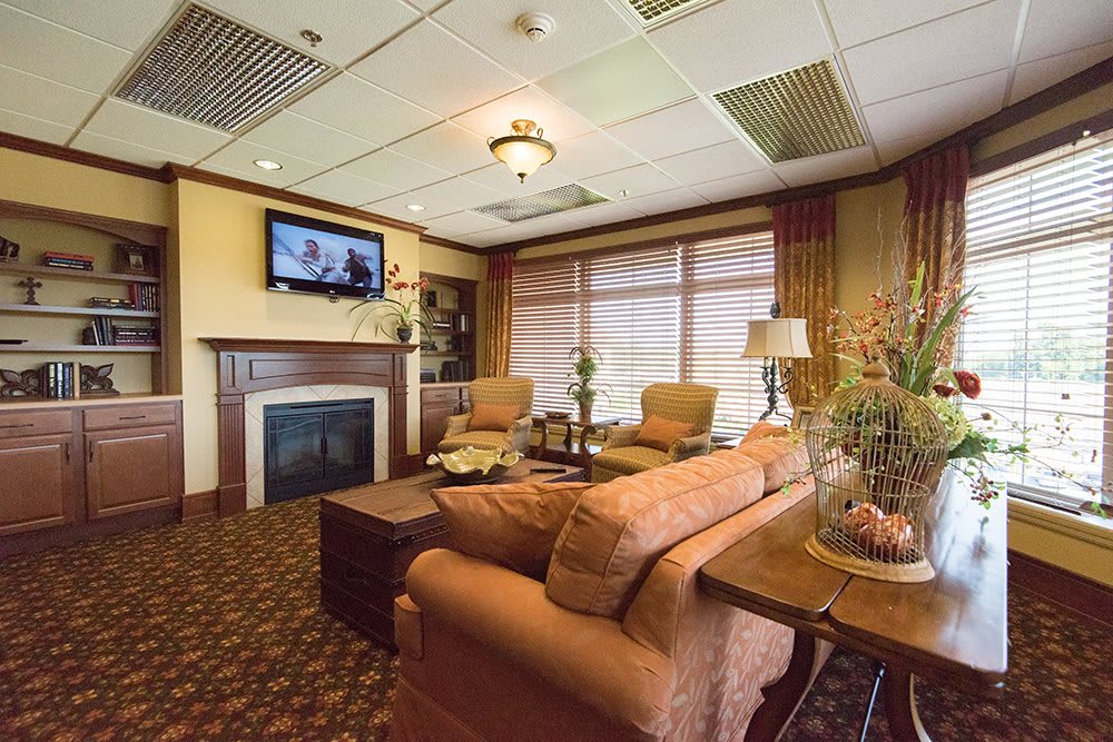 A cozy living room with a sofa, fireplace, and television.