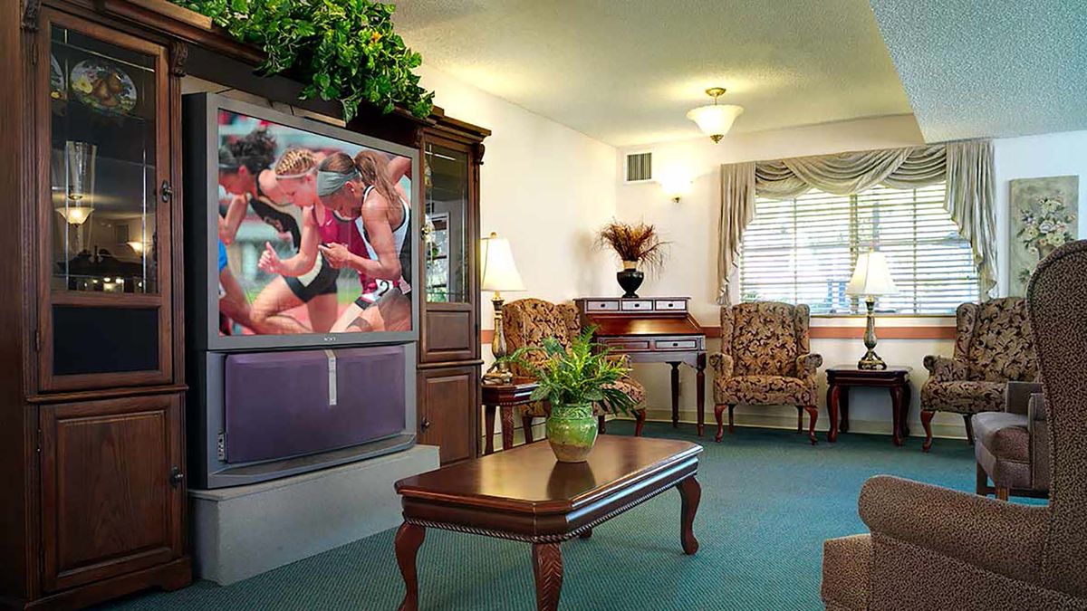 A cozy living room with classic furniture and a large TV.