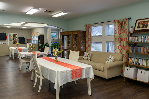 A cozy dining and living area featuring a table set for meals and a comfortable couch, adorned with subtle decor.