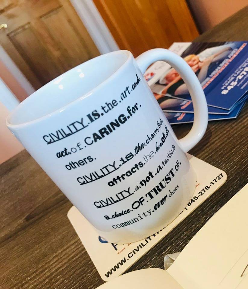 A coffee mug with an inspirational quote about caring and trust on a wooden table.