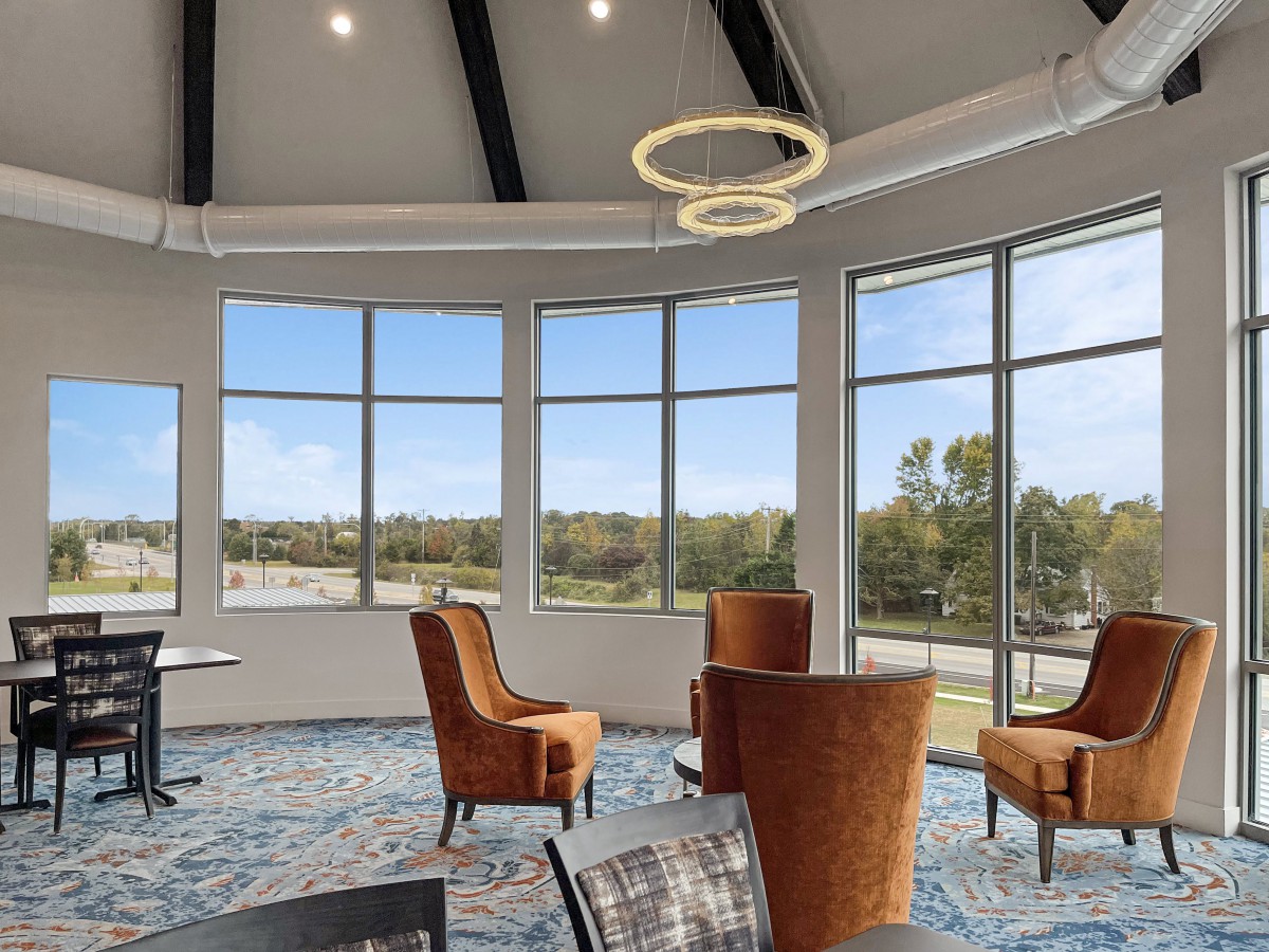 A modern seating area with large windows providing natural light and an outdoor view.