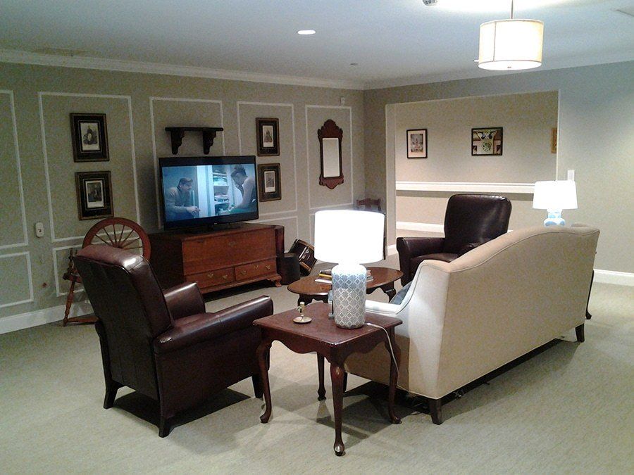 A cozy living room with a television, sofa, armchairs, and a coffee table.