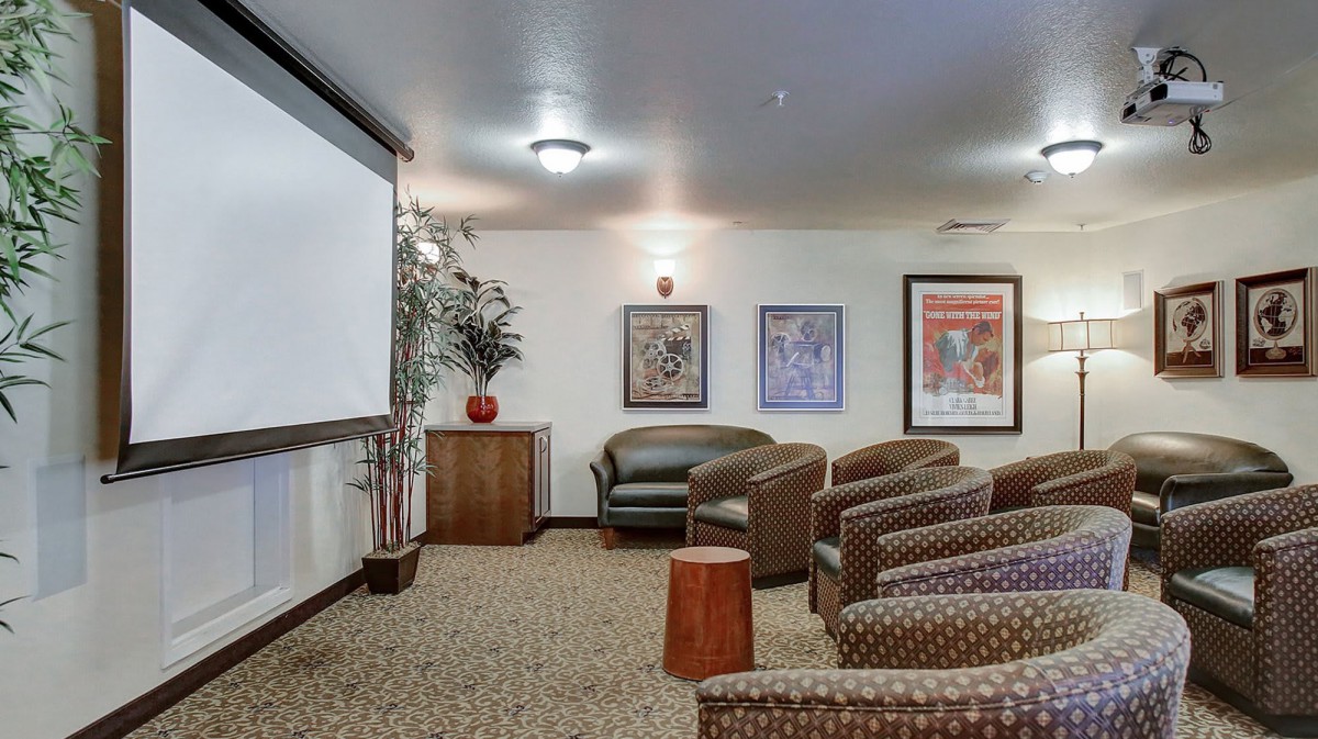 A cozy home theater room with comfortable seating and a large projector screen.
