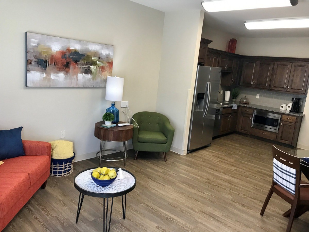 A cozy living space with modern furniture and an open floor plan connecting to the kitchen.