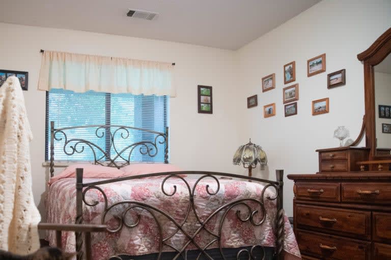A cozy bedroom with a wrought iron bed and wall decor.