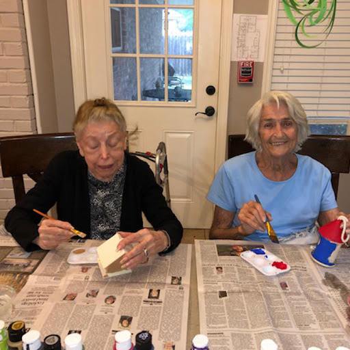 Two seniors enjoying a creative painting session together.