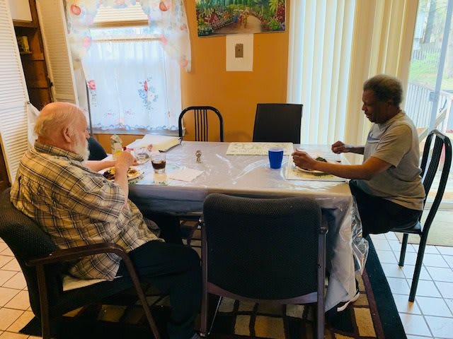 A group of seniors having a conversation around a dining table in a cozy room.