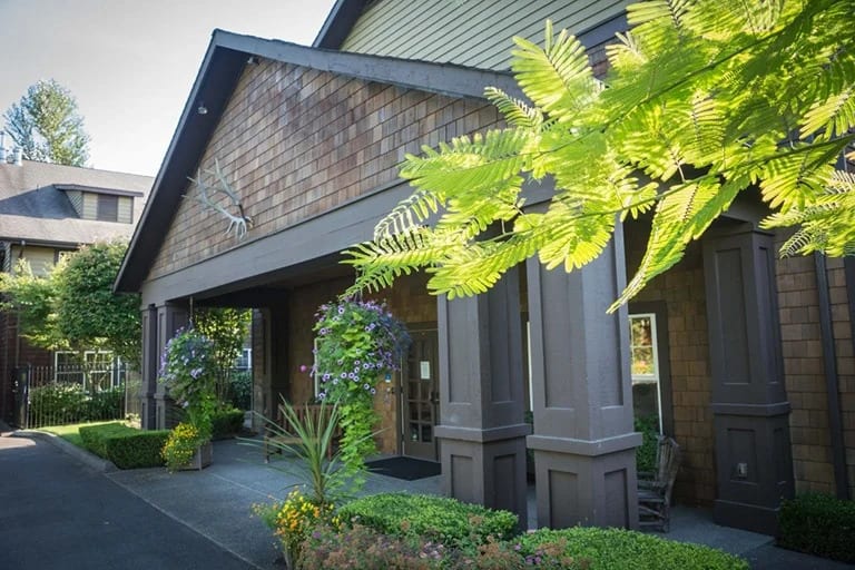 A charming building entrance adorned with lush greenery and decorative plants.