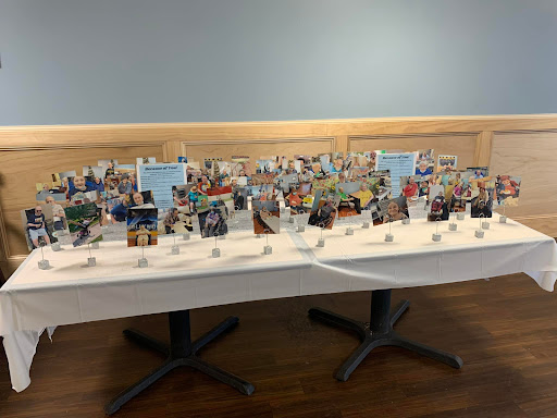 A colorful display of photos and memorabilia arranged on a table during an event.