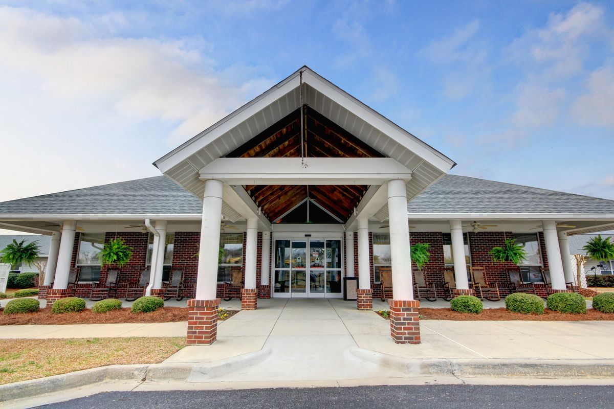 A modern building entrance with columns and brick accents under a clear sky.
