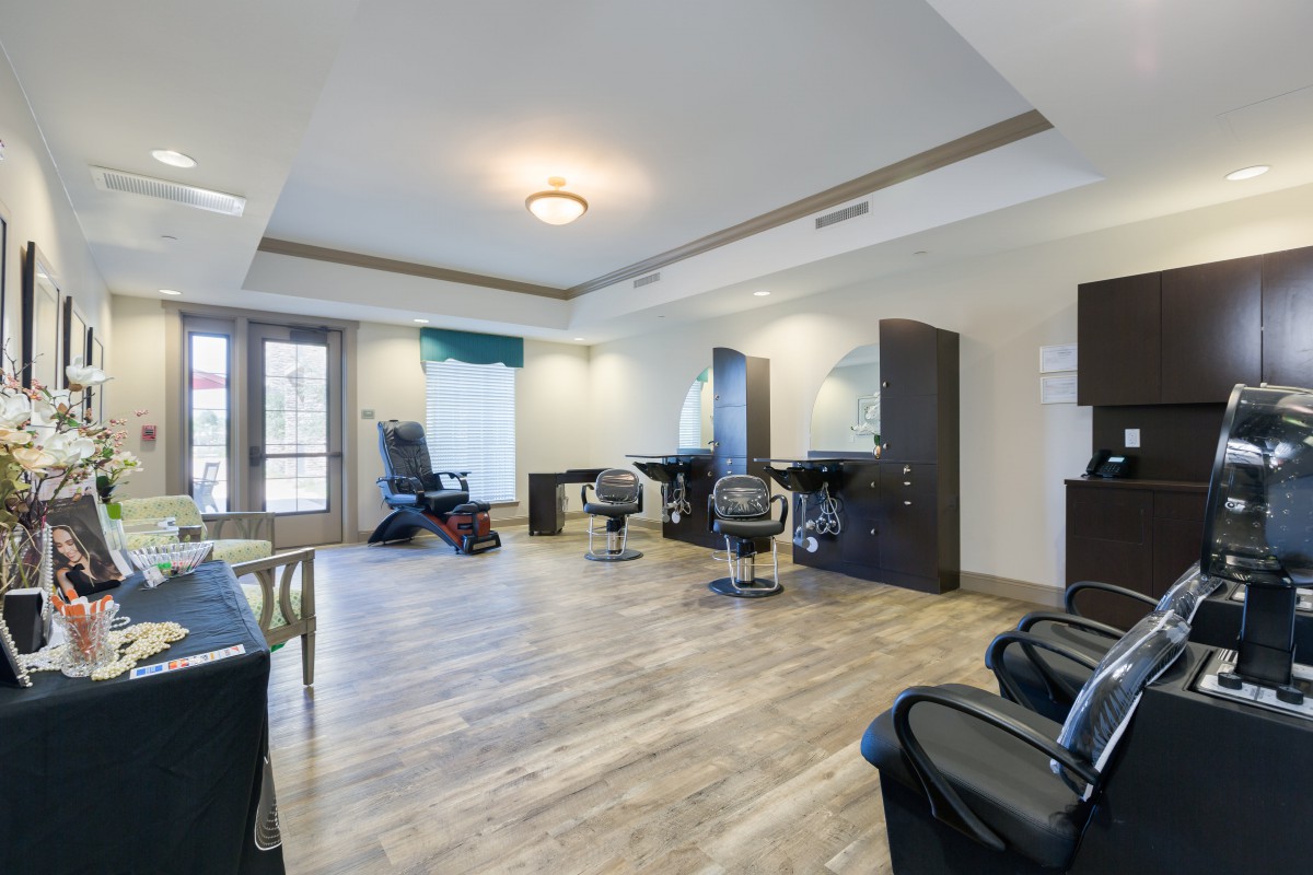 A modern salon interior featuring chairs, mirrors, and wooden flooring.