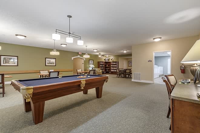 A spacious recreation room featuring a pool table and comfortable seating.