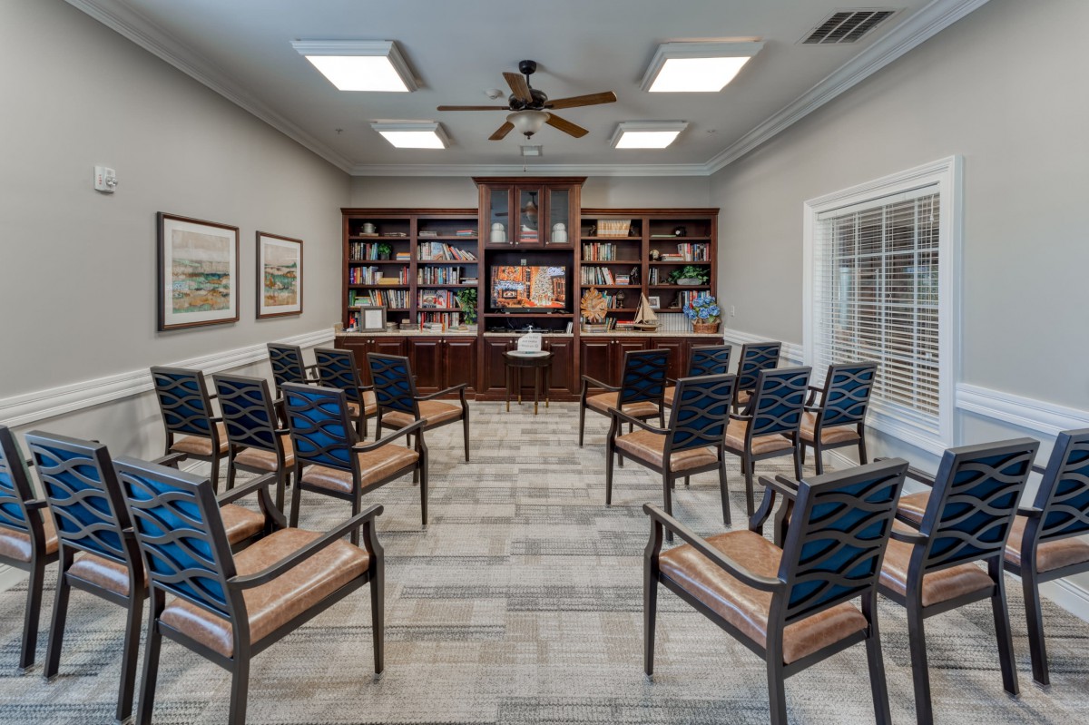 An interior view of a waiting room with neatly arranged chairs and bookshelves.