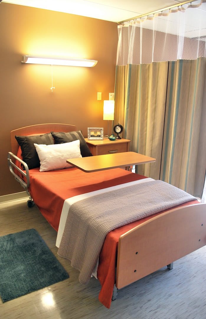 A well-organized hospital room with a bed and side table.