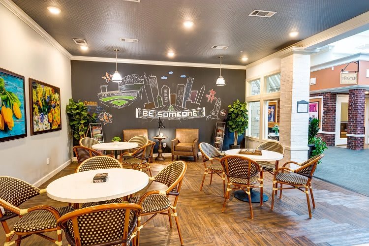 A cozy cafe interior with a chalkboard wall and comfortable seating.