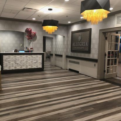 A modern hotel lobby with a stylish reception desk and contemporary chandeliers.