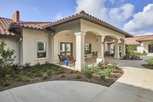 A modern residential home with a covered patio and landscaped garden.