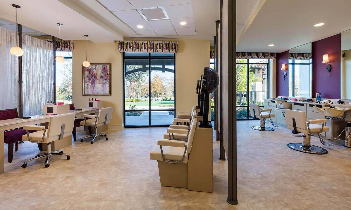 A modern and spacious salon interior with chairs and large windows.