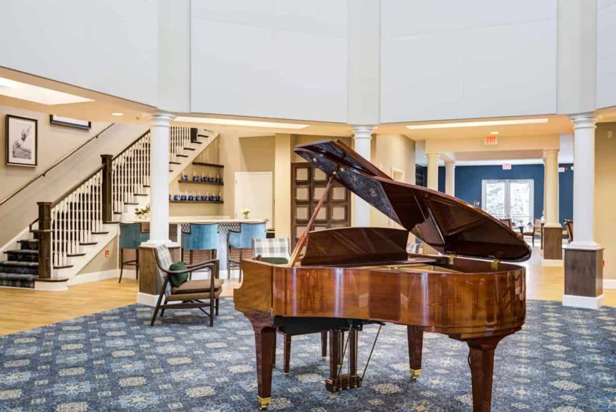 A luxurious hotel lobby with a grand piano and stylish seating area.