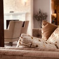 A cozy living room with modern decor and neutral-colored cushions on a sofa.