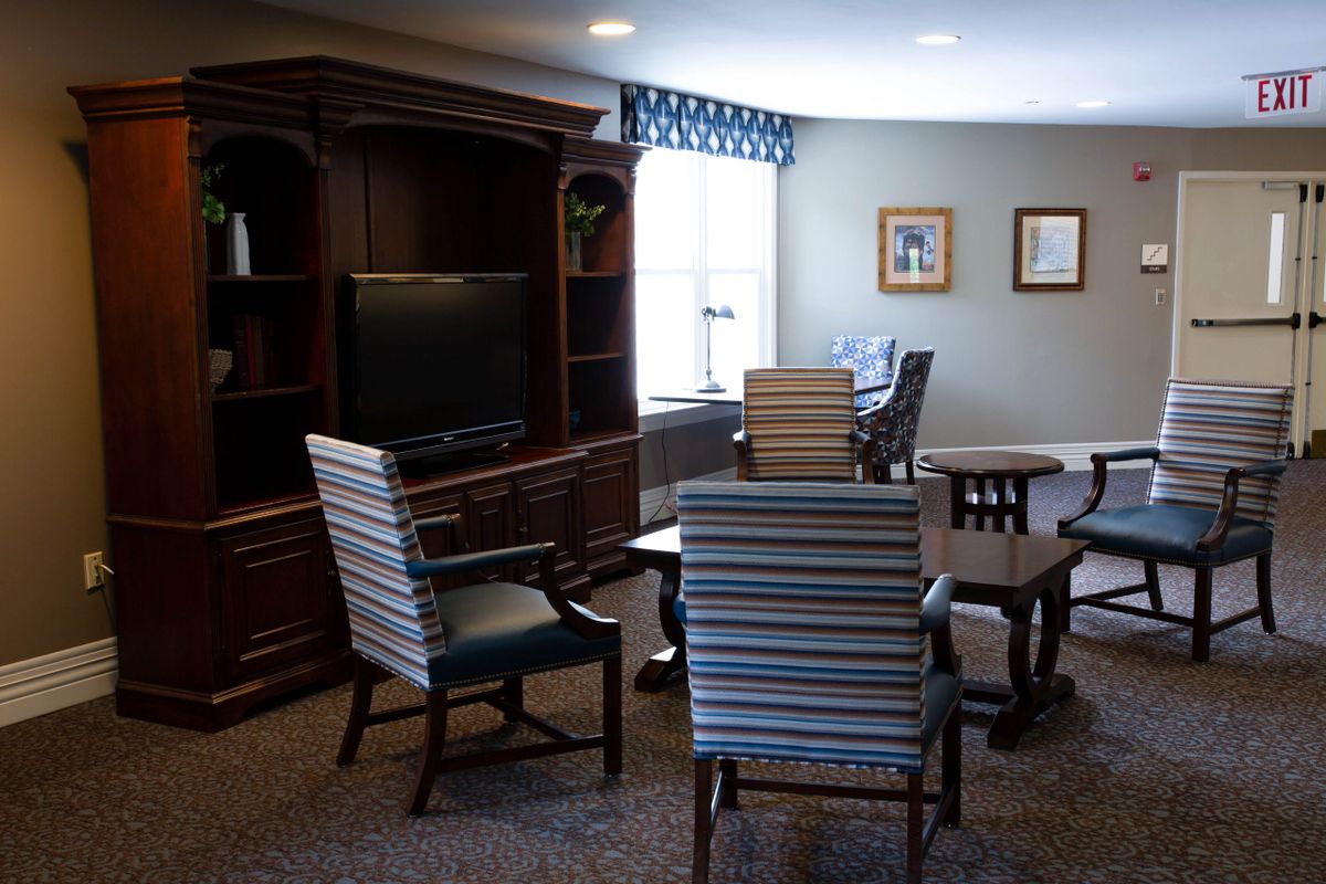 A cozy living room with chairs, a television, and decor.