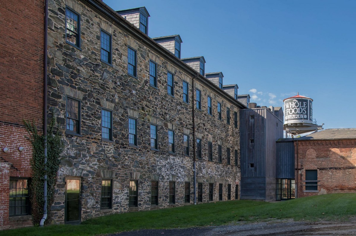 A historic stone building with multiple windows under a clear blue sky.