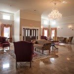 Spacious and elegant lobby with comfortable seating and a chandelier.