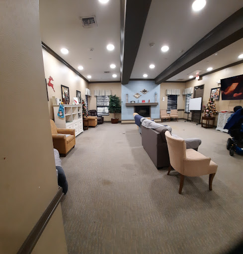 A spacious community lounge area featuring comfortable seating and wall art.