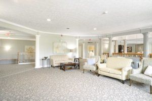 A spacious and well-lit living room with elegant furniture and carpet.